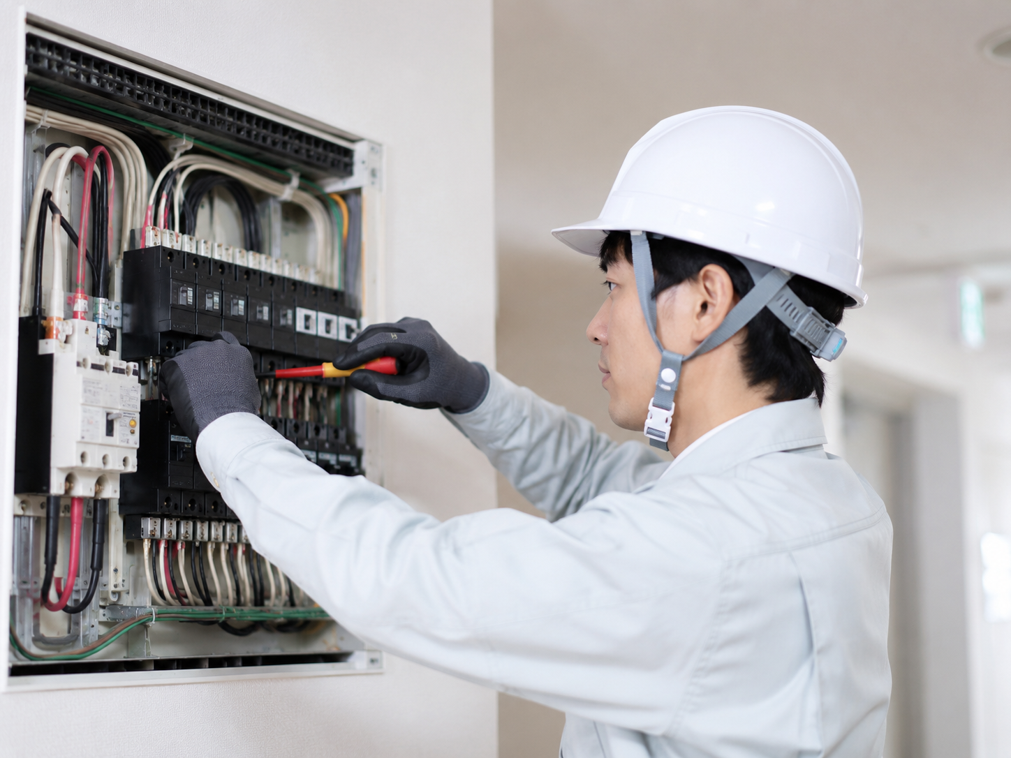分電盤を点検する電気工事士